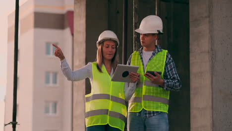 Engineers-or-architects-have-a-discussion-at-construction-site-looking-through-the-plan-of-construction.-contre-jour.-Engineers-or-architects-have-a-discussion